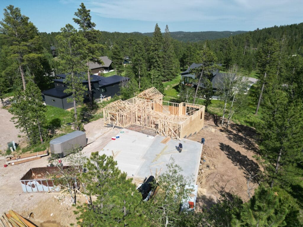 Drone photo of a custom home under construction in the Powder House Pass subdivision in Lead, SD, captured by Odrix Media to showcase professional aerial photography for construction and development projects.