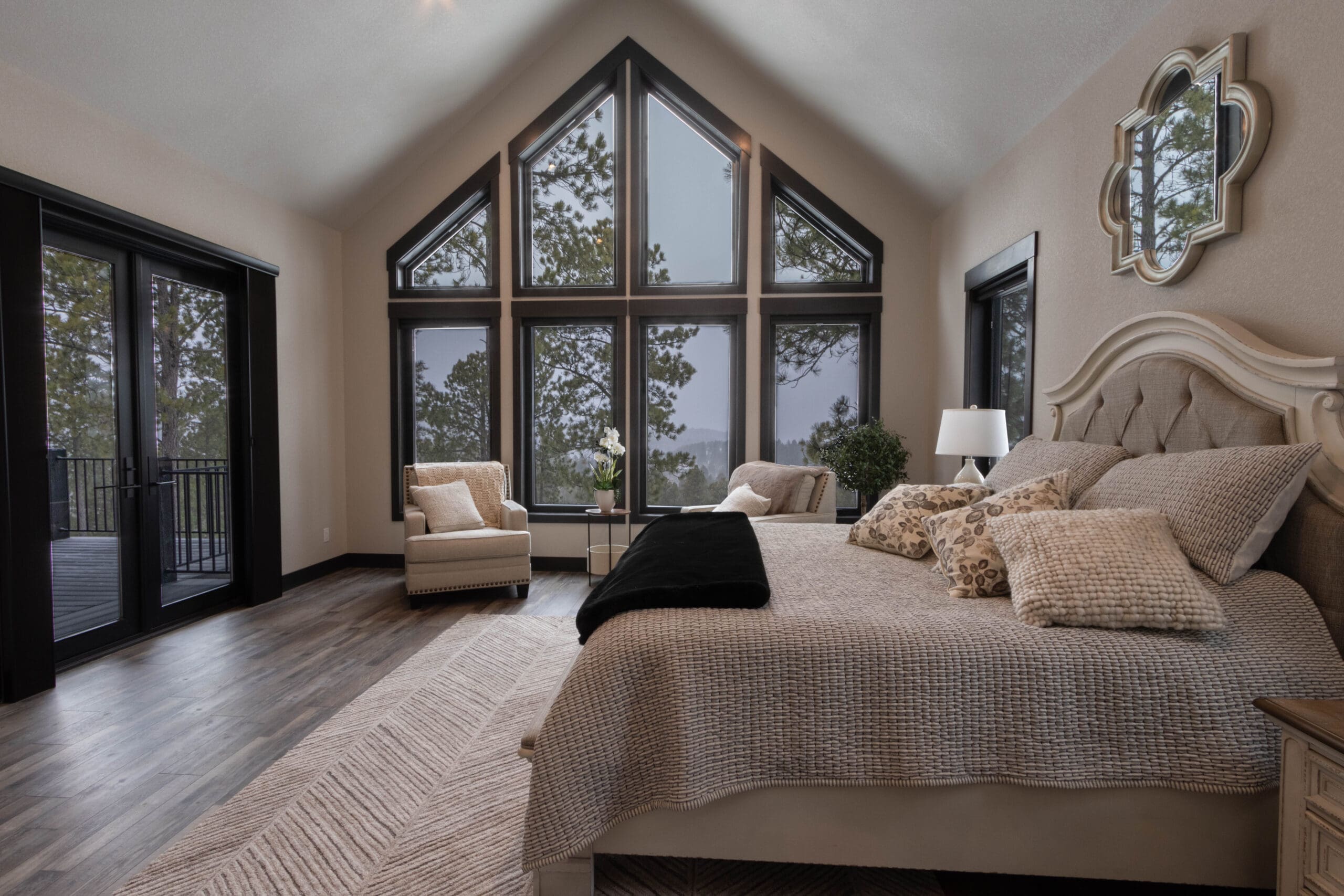 Odrix Media captures a professionally staged bedroom with large cathedral-style windows in a real estate listing in Spearfish, South Dakota.