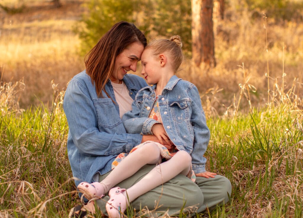 Mother and daughter sharing a candid moment during an outdoor family photography session by Odrix Media and Genesis Ranch Photography in the Black Hills of South Dakota.